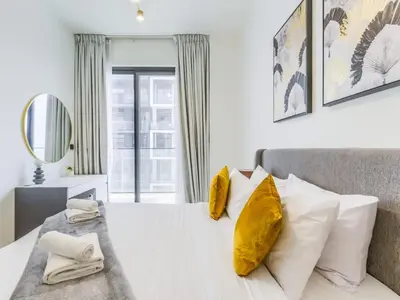 a bedroom with a white bed with yellow pillows at TRPS - Binghatti Nova, Jumeirah Village Circle - Premium 1BR with Great Amenities in Dubai