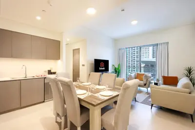 a kitchen and living room with a table and chairs at Livbnb-Modern 2BR with Partial Burj Khalifa View in Dubai