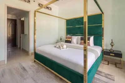 a bedroom with a large bed with a green headboard at Frank Porter - Tejar Tower in Dubai