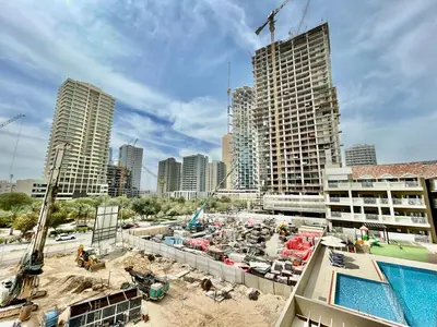 a building under construction in a city with a pool at Homes2Retreat - Serene 1BR Getaway with Stunning Views in Dubai