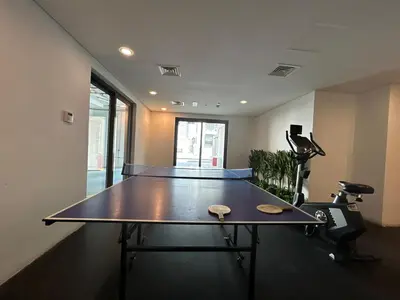a ping pong table in the middle of a room at Homes2Retreat - Serene 1BR Getaway with Stunning Views in Dubai