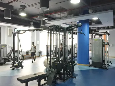 a gym with several tread machines and people in the background at GuestReady - Chic High-Rise with Canal Views in Dubai
