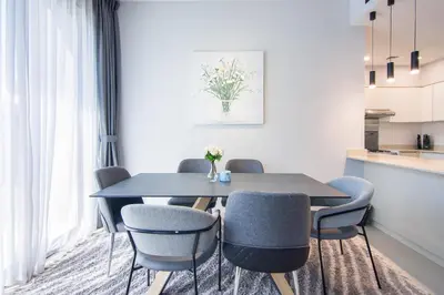 a dining room with a black table and blue chairs at Elegant 4 bedrooms plus maid Villa in the Heart of Dubai Hills in Dubai
