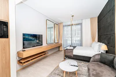 a hotel room with a bed and a tv at Escape24 Cozy Studio with Pool View in JVC in Dubai
