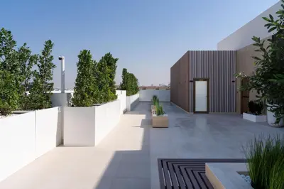 a courtyard of a house with white fences and plants at Spacious Luxury 1br Jvc Balcony & Pool in Dubai