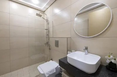 a bathroom with a sink and a mirror and a toilet at Daniels 2BR at Jumeirah Garden City in Dubai