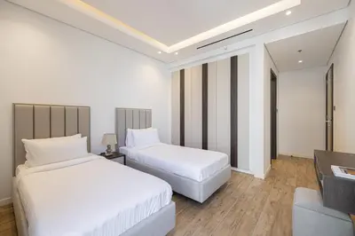 a hotel room with two beds and a television at Daniels 2BR at Jumeirah Garden City in Dubai