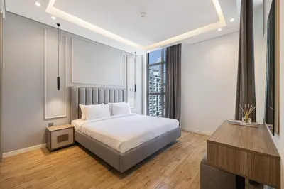 a bedroom with a bed and a tv and a window at Daniels 2BR at Jumeirah Garden City in Dubai