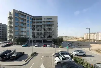 a parking lot with cars parked in front of a building at B&B retro in Dubai