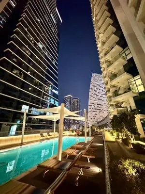 a view of a city with tall buildings at night at Mahogany 6 - 2BR 8PAX - Infinity Pool & High-floor in Dubai