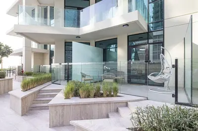 a modern house with glass walls and a patio at Mahogany 6 - 2BR 8PAX - Infinity Pool & High-floor in Dubai