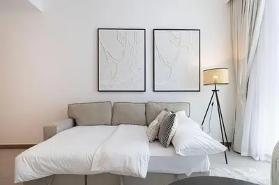 a bedroom with a couch and three pictures on the wall at Mahogany 5 - 2BR 6PAX - Infinity Pool & High-floor in Dubai