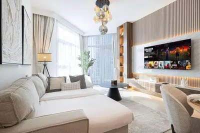 a living room with a couch and a tv at Mahogany 5 - 2BR 6PAX - Infinity Pool & High-floor in Dubai