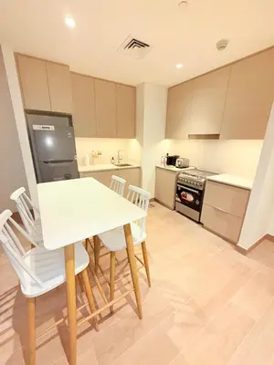 a kitchen with a white table and chairs at 1 Bed With Private Beach Access In Dubai Creek Harbour in Dubai