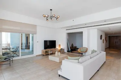 a living room with white furniture and a tv at Marina Residence 4, Palm Jumeirah - Mint Stay in Dubai