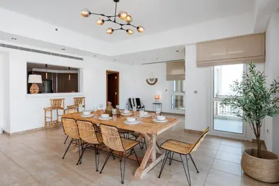 a kitchen and dining room with a wooden table and chairs at Marina Residence 4, Palm Jumeirah - Mint Stay in Dubai