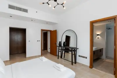 a bedroom with a bed and a mirror and a table at Marina Residence 4, Palm Jumeirah - Mint Stay in Dubai
