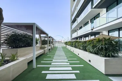 an office building with a walkway with plants at Skyline and Community Views 1BR with Private Balcony Near Community Park, Binghatti Amber, Jumeirah Village Circle by Deluxe Holiday Homes in Dubai