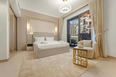 a bedroom with a bed and a couch and a chair at Modern Compact Studio in JVC in Dubai
