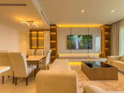 a living room with a table and chairs and a tv at Elegant 2-BR with modern comfort in Dubai