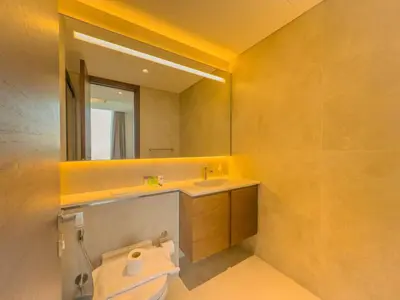 a bathroom with a sink and a mirror and a toilet at Elegant 2-BR with modern comfort in Dubai