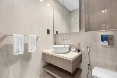 a white bathroom with a sink and a mirror at Luxury 1BR in Business Bay with Burj Khalifa Views, Balcony, Pool and Gym Access in Dubai