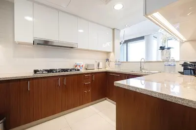 a large kitchen with wooden cabinets and a sink at 4BR Luxury Apartment with Burj Khalifa View and Direct Dubai Mall Access - Pool and PS5 Included in Dubai
