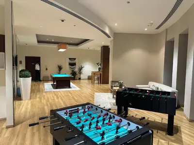 a living room with a foosball table in the middle at 4BR Luxury Apartment with Burj Khalifa View and Direct Dubai Mall Access - Pool and PS5 Included in Dubai