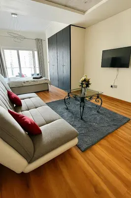 a living room with a couch and a table at Modern Studio with Balcony - Close to Metro & Marina in Dubai