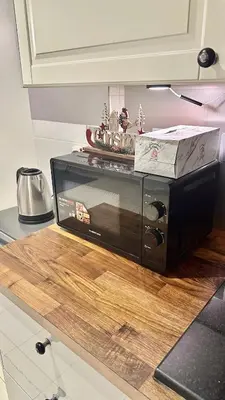 a microwave sitting on top of a table at Modern Studio with Balcony - Close to Metro & Marina in Dubai