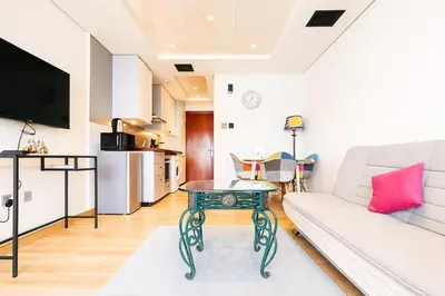 a living room with a couch and a table at Modern Studio with Balcony - Close to Metro & Marina in Dubai