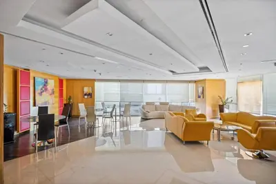 a lobby with a couch and a table and chairs at Modern Studio with Balcony - Close to Metro & Marina in Dubai