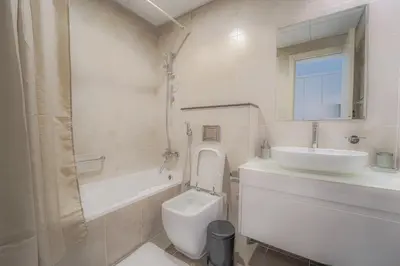 a white bathroom with a sink and a toilet and a tub at Studio in Damac H1 by Deleguest in Dubai