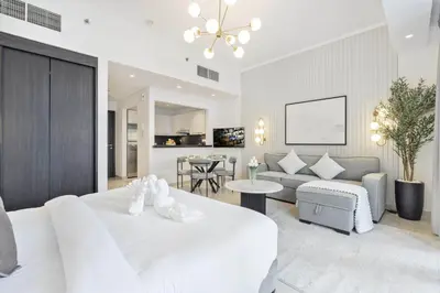 a bedroom with a white bed and a living room at Luxury Studio in Dubai Marina with Canal views in Dubai
