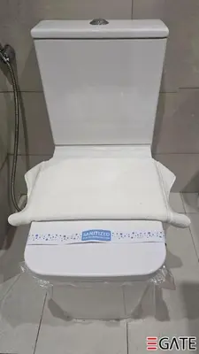 a white toilet with towels on top of it at EGATE - Studio - 1st Floor with Terrace - Dubai - 31-109 in Dubai