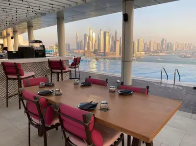 a table and chairs with a view of the city at High-floor 1 Bedroom by Seven Apartments Palm Jumeirah in Dubai