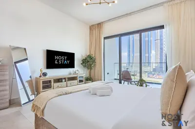 a bedroom with a large bed and a large window at Cozy Studio in Binghatti Canal - Close to Downtown in Dubai