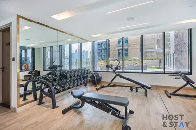 a gym with several treadmills and elliptical machines at Cozy Studio in Binghatti Canal - Close to Downtown in Dubai
