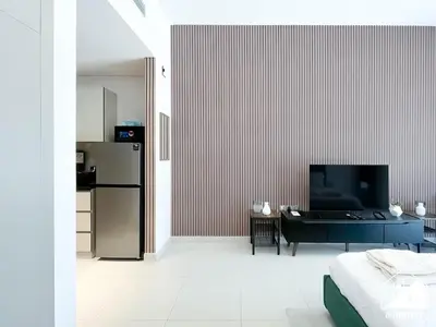 a living room with a black table and a refrigerator at Serene Studio with Views in Al Waleed Garden 2 in Dubai
