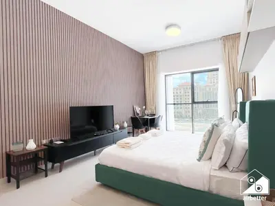 a bedroom with a large bed and a television at Serene Studio with Views in Al Waleed Garden 2 in Dubai