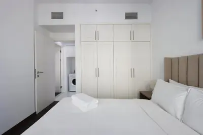 a bedroom with a white bed and white cabinets at Livbnb-Upgraded 3B with Marina View,Near Promenade in Dubai