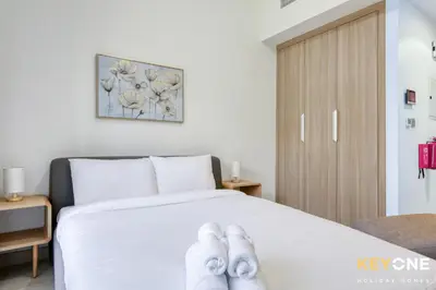 a bedroom with a bed with white shoes on it at Chic Modern Studio in Azizi Riviera in Dubai