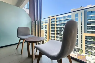 two chairs and a table on a balcony at Chic Modern Studio in Azizi Riviera in Dubai