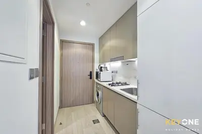 a kitchen with a sink and a stove top oven at Chic Modern Studio in Azizi Riviera in Dubai