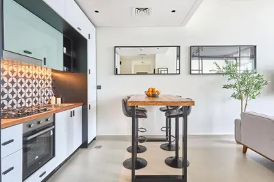 a kitchen with a counter and a bar with stools at Fresh & Stylish 2br Living At Collective Tower 1 in Dubai