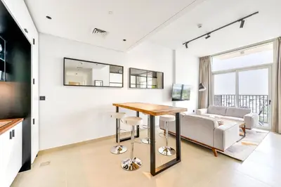 a living room with a table and a couch at Fresh & Stylish 2br Living At Collective Tower 1 in Dubai