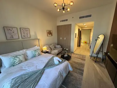 a bedroom with a bed and a living room at Amazing Studio for Rent in Dubai