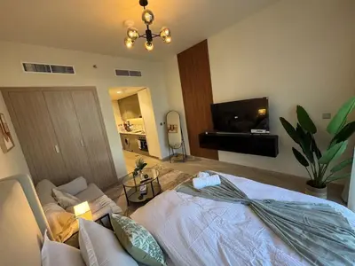a bedroom with a bed and a living room at Amazing Studio for Rent in Dubai