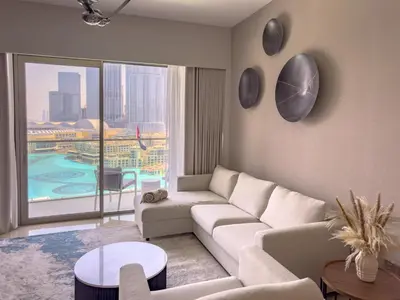 a living room with a couch and a large window at GRANDE SIGNATURE with a direct Burj Khalifa view and Private Fountain Show with DXB AIRPORT VIP Shuttle option for 8 guests in Dubai