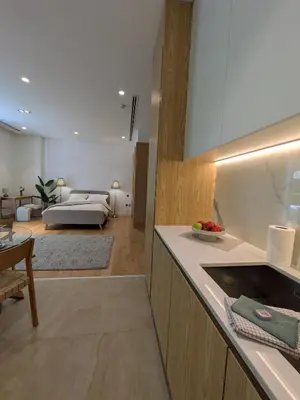 a kitchen and living room with a bed in the background at Stylish Urban-Jungle-Studio in Al Barari, Dubai in Dubai